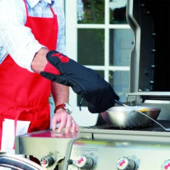 Weber Grills Black With Red Kettle Cotton Grill Glove With Extra Long Cuff -BBQGrills Shop Weber Black with red kettle cotton grill glove resting in use